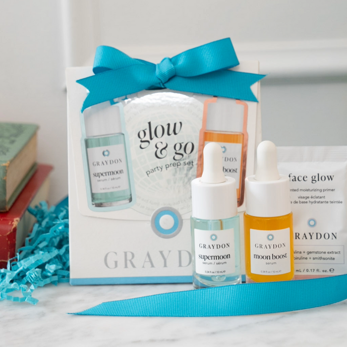a photo of the graydon skincare glow and go party prep set on a bathroom counter. the set includes a 10ml supermoon serum, a 10ml moon boost, and a 5ml face glow