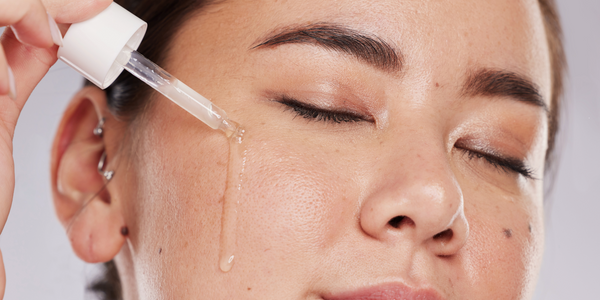 woman applying retinol serum to her face