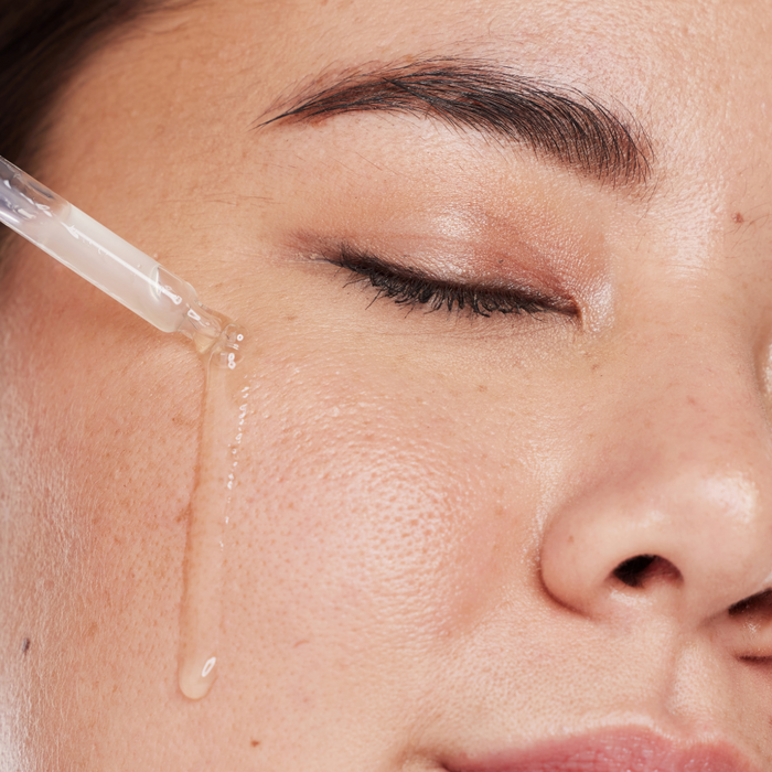 woman applying retinol serum to her face